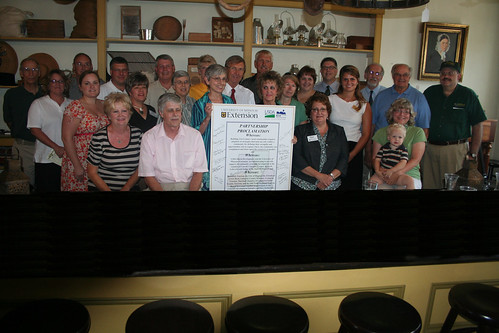 Regional partnership participants and the proclamation. Immediately behind the document are (left to right) Mary Simon Leuci, Community Development Program Director for University of Missouri Extension and Assistant Dean for the College of Food, Agriculture and Natural Resources; Don Borgman, Chair of the Old Trails Regional Tourism Partnership; and Janie Dunning, Missouri State Director for USDA Rural Development.
