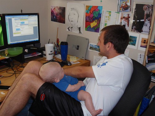 Man working on laptop with kid in lap