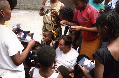 Image of Jeff Behringer with Haitian children, whom he supports with profits from Behringer Stone Company and with his expertise in building and repairing masonry