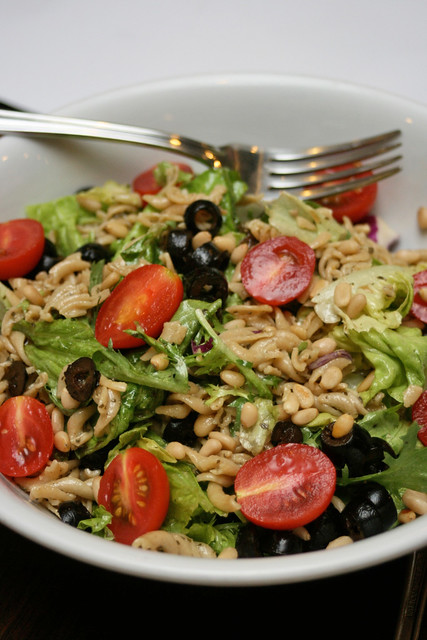 Wholemeal pasta salad with olives, tomatoes and pine nuts