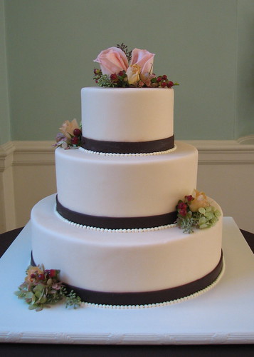 Ivory fondantcovered wedding cake banded with hand cut chocolate brown 