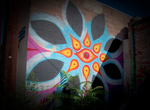 graffiti of big, multicolored flower mandala with eye at the center