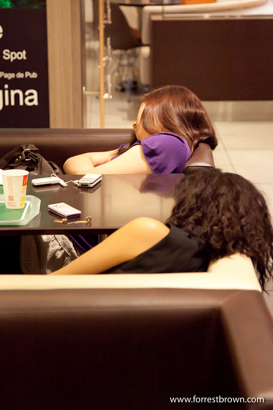 Person sleeping in a Japanese fast food restaurants.