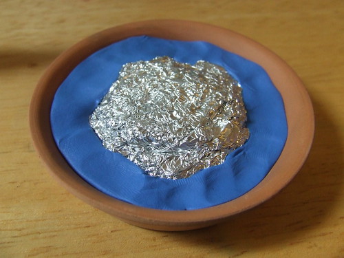 Clay and foil squeezed into base