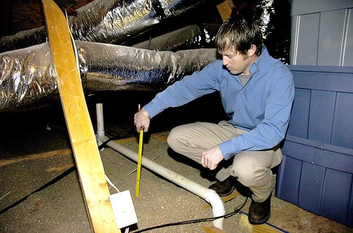 United Energy Conservation Coordinator Seth Rosser measures insulation as part of an energy audit at a member's home.  (Photo courtesy of United Cooperative Services)