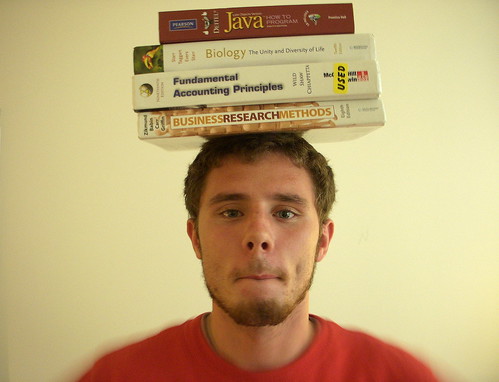 Imaeg of man with books balanced on head