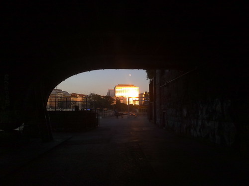 An einem Bürhaus am Donaukanal reflektierende Sonne von unter einer Brücke aus.