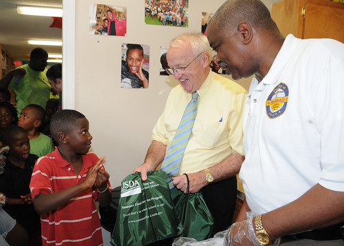 FNCS Under Secretary Kevin Concannon and Prichard Mayor Ron Davis hand out USDA Summer Food Service Program backpacks and lunches to children participating in the Summer Food Service Program at Light of the Village in Prichard, Ala., July 8.  