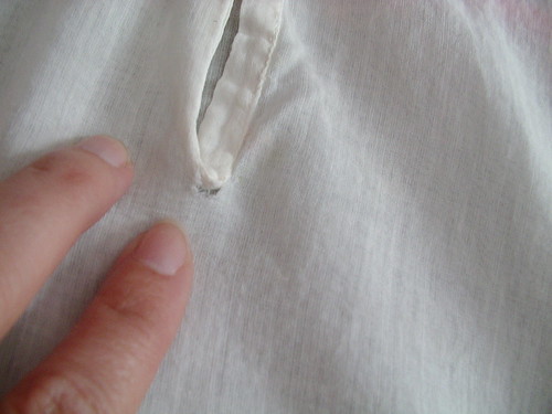 tear at back on button placket.