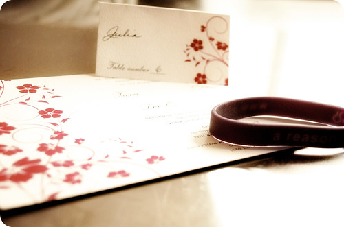  atop their table setting containing a purple rubber awareness bracelet