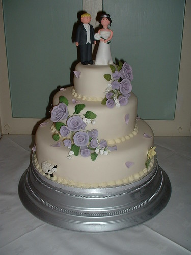 3 tiered wedding cake with lilac roses and premade bride and groom wedding