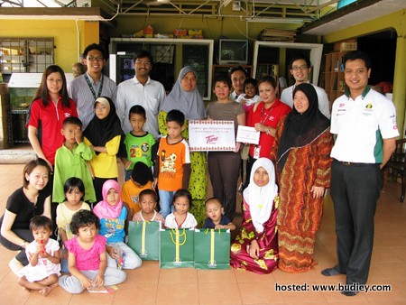 Tune Group staff presenting cash donation and goodies to residents of Rumah Titian Kasih 2