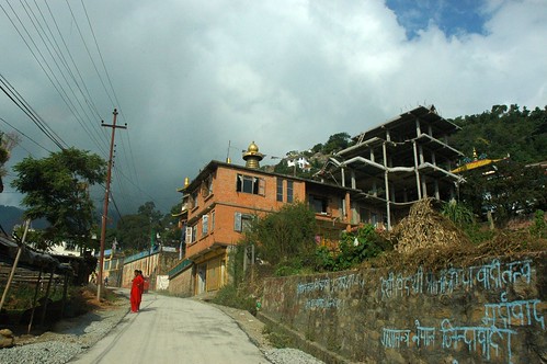 Nepalese graffitti, new construction, two women wearing red chubas, storm weather, Tibetan Monastery, road to Pharping, Nepal by Wonderlane