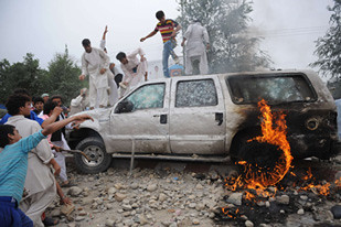 Afghanistan youth destroy United States embassy vehicles after civilians were killed by the SUVs. Demonstrators chanted "Death to America" and prompted the dispatch of military occupation forces to put down the unrest. by Pan-African News Wire File Photos