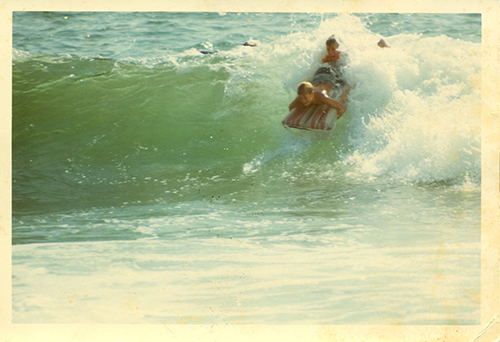 dad + brothers playing in the surf