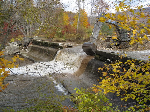 An excavator begins demolition of Briggsville Dam. 