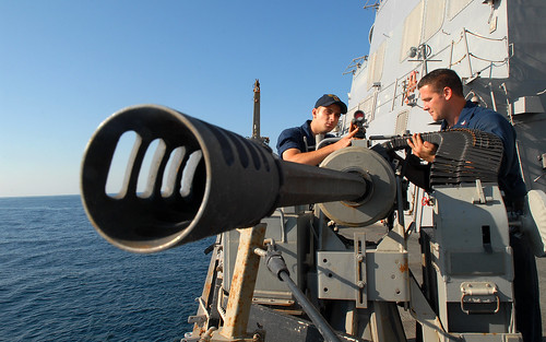 Navy gunner's mates inspect machine gun.