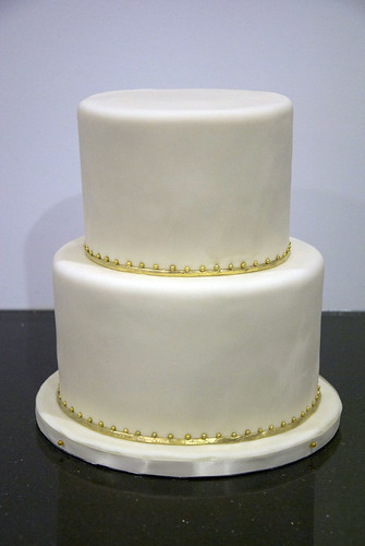 A very simple 2 tier ivory wedding cake with a delicate gold border to place