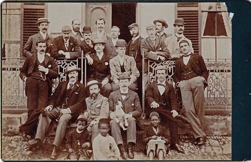Group of men with dog and African boys. British East Africa? North Africa?