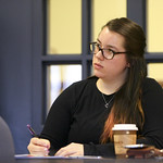 A student taking notes as she listens during class.