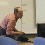 Dr. Fischmar glances at the computer to aid him in his lecture.