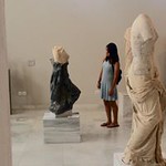 An Honors student gazes at a sculpture in a museum in Athens.