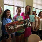 Students and faculty pose for a picture with a Westminster poster