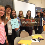 Students and faculty pose for a picture with a Westminster poster