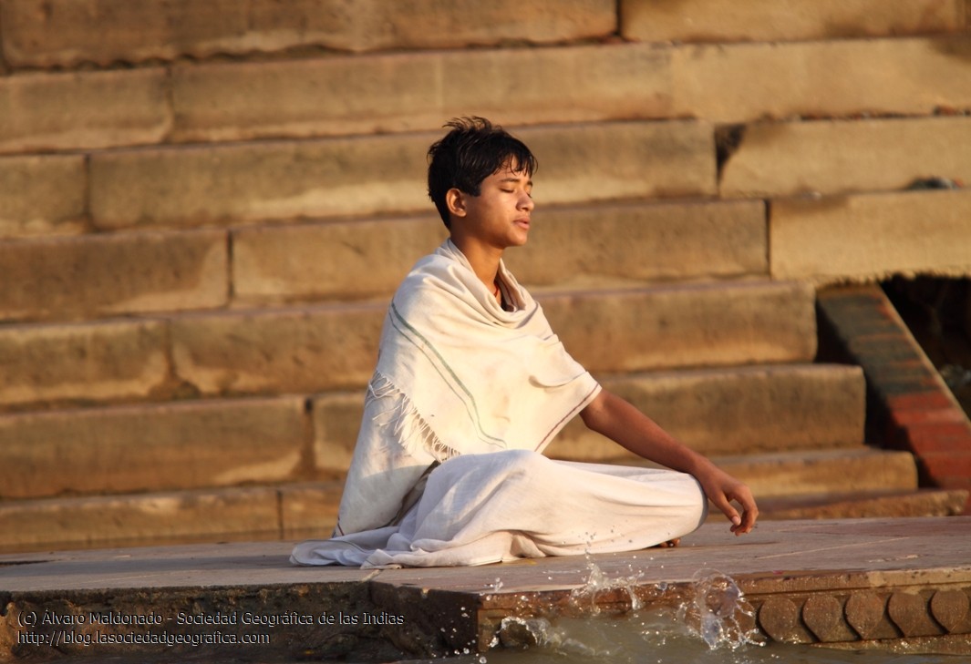 Joven rezando al amanecer en Varanasi