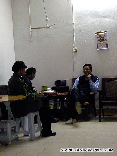 Nic's uncle sipping tea with the restaurant owner and staff