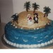 Desert island themed wedding cake with bride and groom topper.