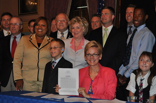 Conor Waterman and Katie Birchmeier stand with Michigan Governor Jennifer Granholm, Michigan House Reps. Pam Byrnes and Jon Switalski, and others at a recent ceremonial bill signing event for Complete Streets legislation.