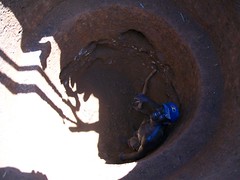 A local man helps to dig the well