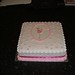 Square ballerina cake with pink decorations and ribbon.