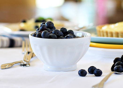 A white bowl filled with fresh blueberries. 