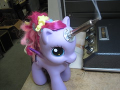 A purple My Little Pony figurine with a fuchsia mane. A soldering iron emerges from its forehead, pointing just to the right of the camera.