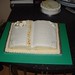 50th wedding anniversary cake in the shape of a book with flower decorations.