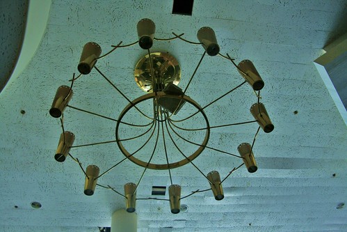 Grand brass chandelier suspending falling ceiling tile