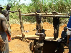 A man being lowered into the well during excavation