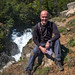 A happy photographer relaxing close to a waterfall on Los Maquis river near Puerto Guadal