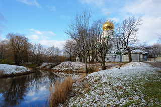 First snow. Cathedral on the shore of the blue lake.